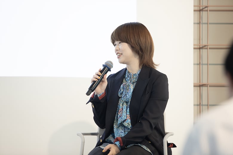 岸田さんがマイクを持ち、笑顔で話している様子