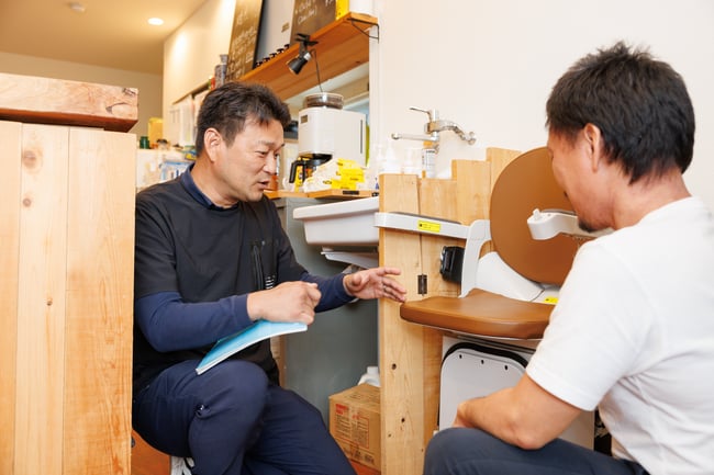写真　正和工業の吉本さんが車いすを触っている様子