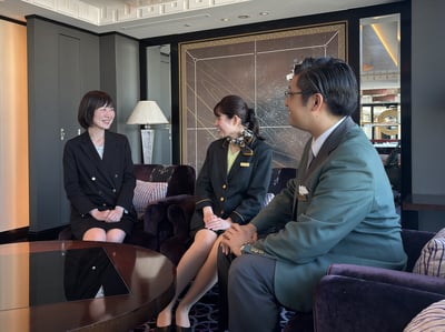 （写真）ニューオータニの社員3名が向かい合って話している様子