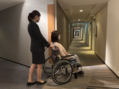 （写真）ホテル館内を車いすで移動している様子