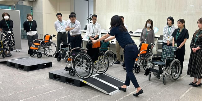 写真　車いす実技研修でスロープの上り下りについて講師が説明している様子