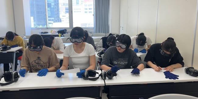 写真　学生さんが高齢者実技研修で読みにくい文字を見ている様子