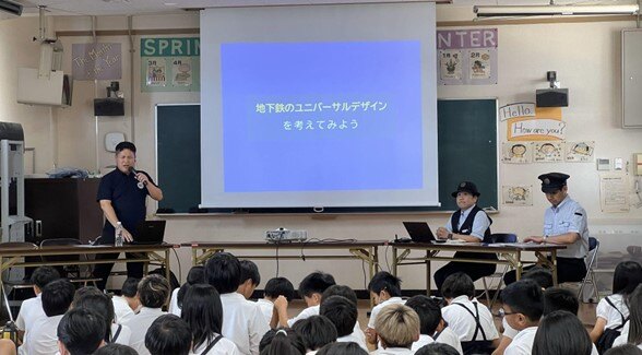 写真　地下鉄のユニバーサルデザインについて講師が説明している様子