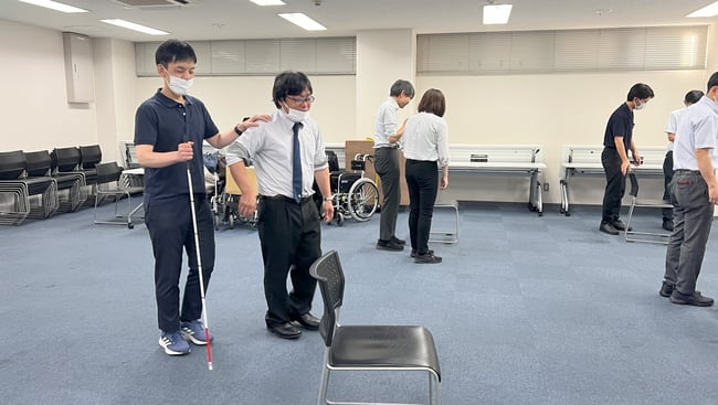 （写真）車いす実技研修で車いすを押している様子