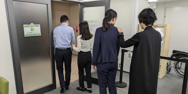 （写真）視覚障害者実技研修で誘導のサポートを体験している様子