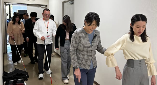 （写真）視覚障害の実技研修中に、誘導サポートの方法を実践している様子