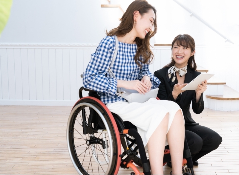 （写真）車いすユーザーへ接客している様子