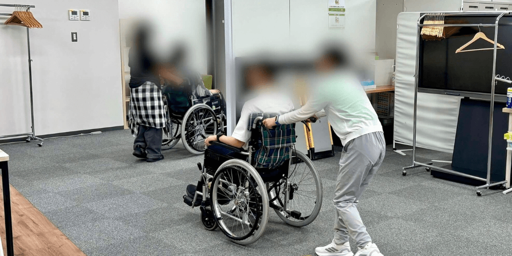 （写真）子どもたちが車いすを押す体験をしている様子